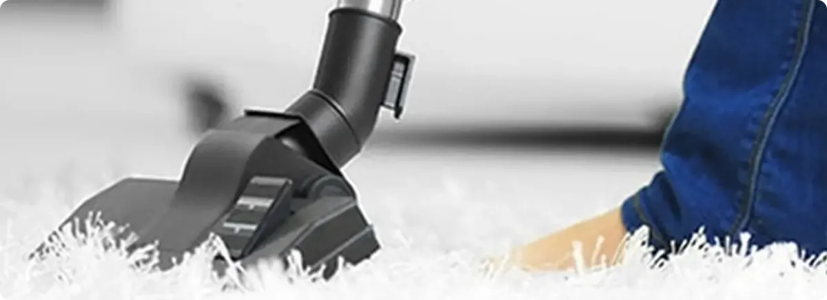 Close-up of a professional vacuuming a white carpet in Sellersburg.